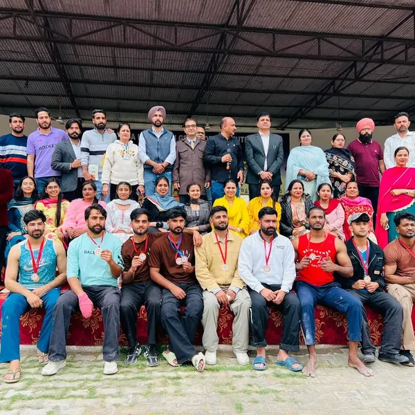 Students and staff in a group photo, some wearing medals