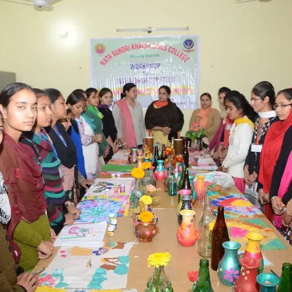 Students at a table of decorated pots and craft work