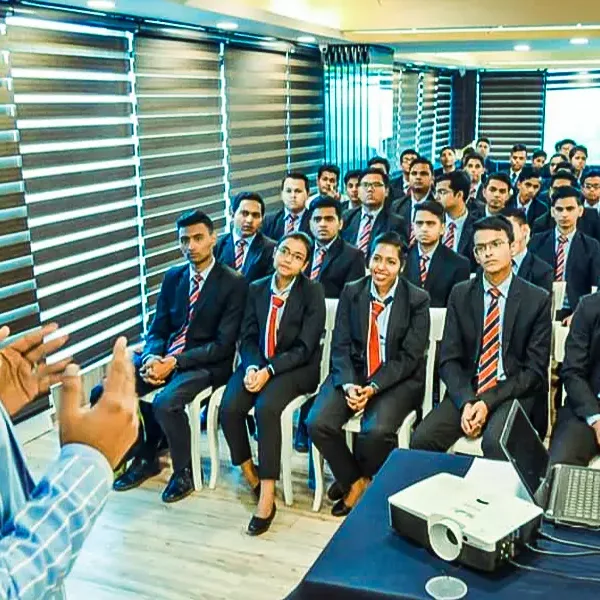 Hotel management students in suits at a classroom session